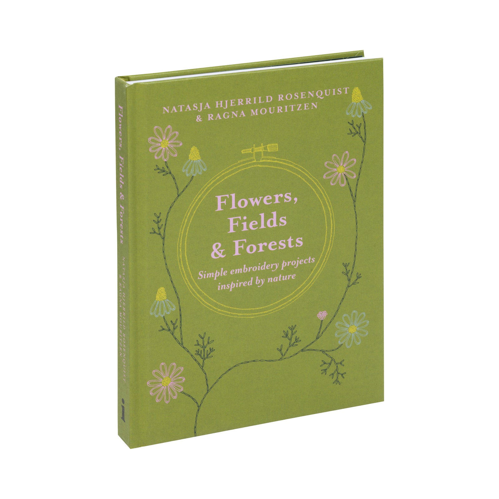 An open embroidery book with a green cover titled "Flowers, Fields & Forests" placed over an open page showing a navy blue fabric sample with a pink flower embroidery.