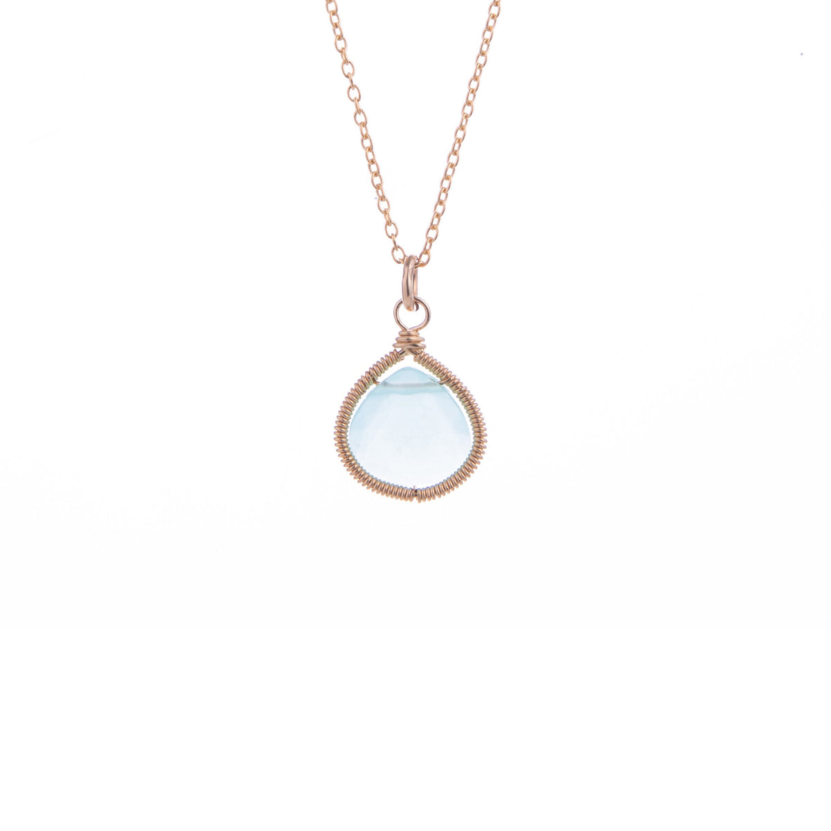 A rose gold necklace with a teardrop-shaped light blue gemstone wrapped in textured rose gold wire, shown against a plain white background.
