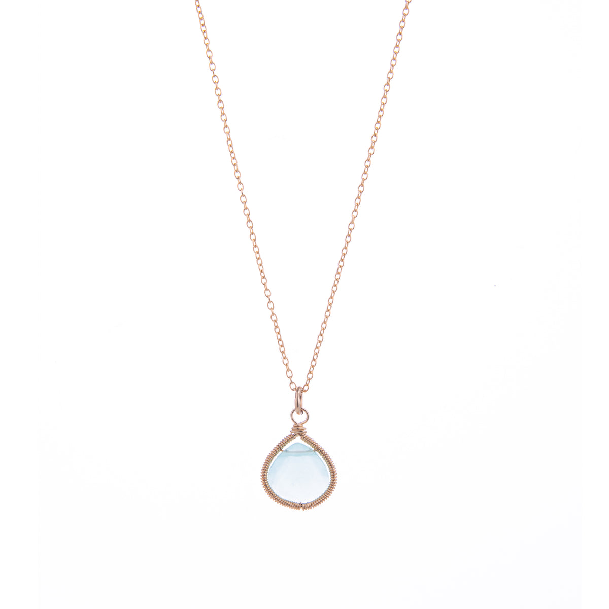A rose gold necklace with a teardrop-shaped light blue gemstone wrapped in textured rose gold wire, shown against a plain white backgroun