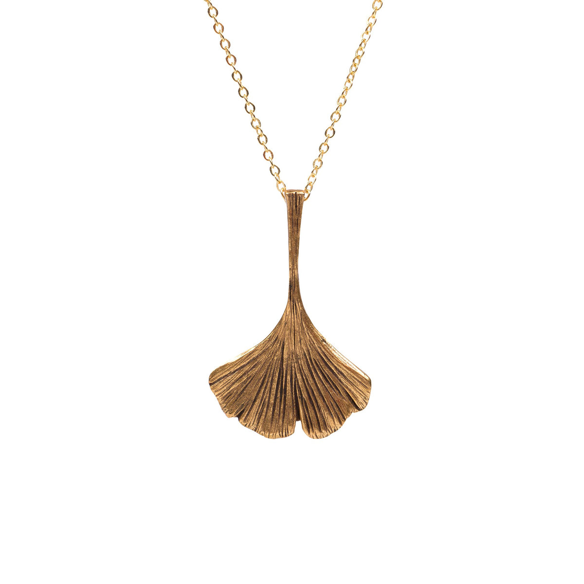 A gold pendant necklace featuring a textured, fan-shaped ginkgo leaf design hanging from a delicate gold chain against a solid white background.