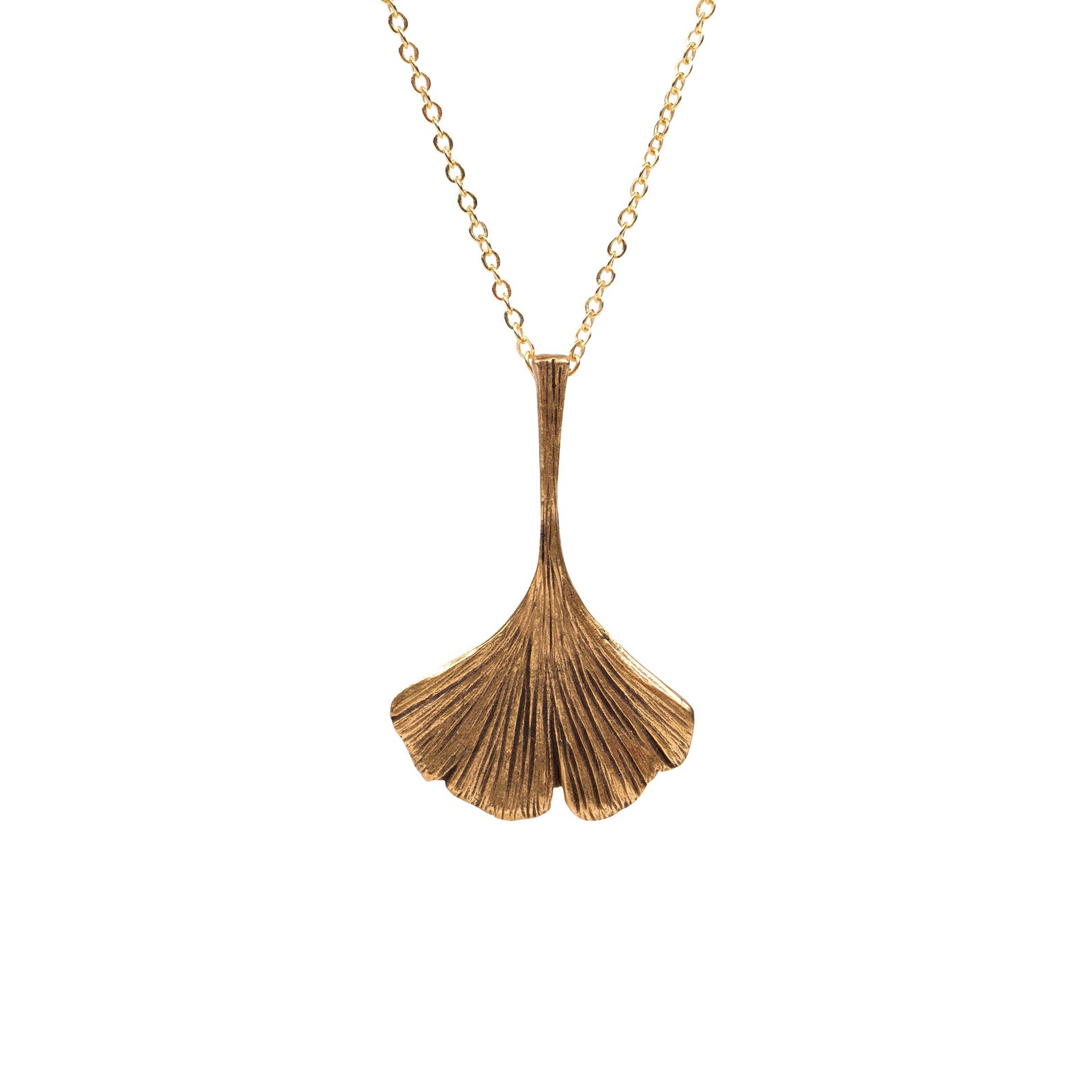 A gold pendant necklace featuring a textured, fan-shaped ginkgo leaf design hanging from a delicate gold chain against a solid white background.