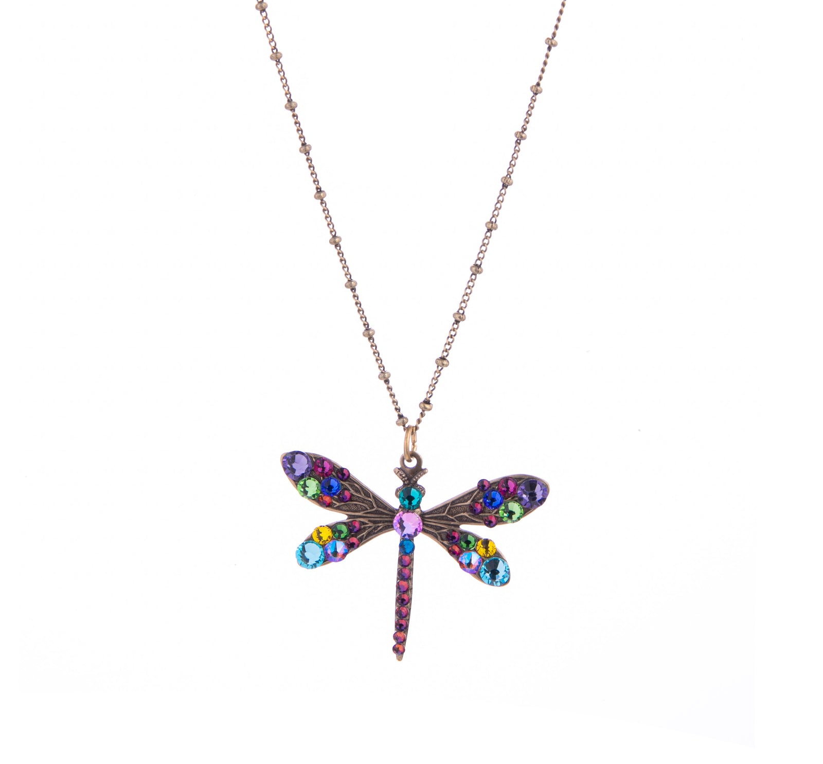 This Dragonfly Necklace with multi-colored crystal detail and intricate metalwork and its rainbow-colored sparkle will look truly special and stand out against any color you wear with it.  Material: Antiqued brass Dimensions: Approx. 1" Pendant, Adjustable Chain 16”-18" Lead, Nickel-free Lobster claw closure