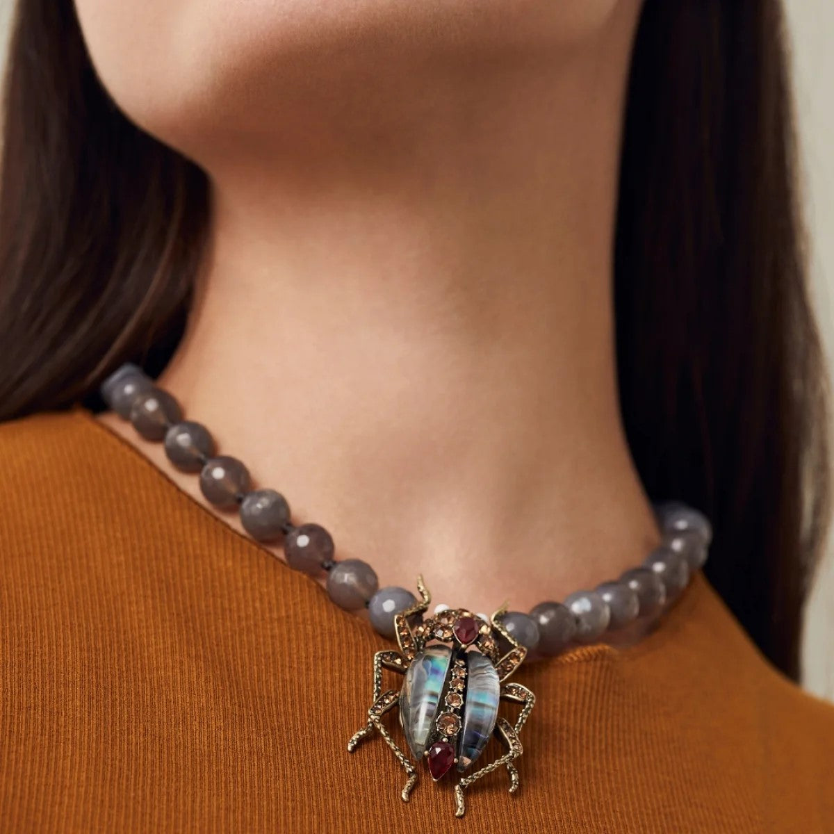 With antique gold detailing for a vintage feel, you will be turning heads with this Jewelled Beetle Statement Necklace. The resin stones and hand set crystals make up this stunningly iridescent beetle. Materials: Swarovski Crystals, Agate Beads Dimensions: Approx. 18" Length, 1.4" x 2" - Pendant Magnetic Clasp