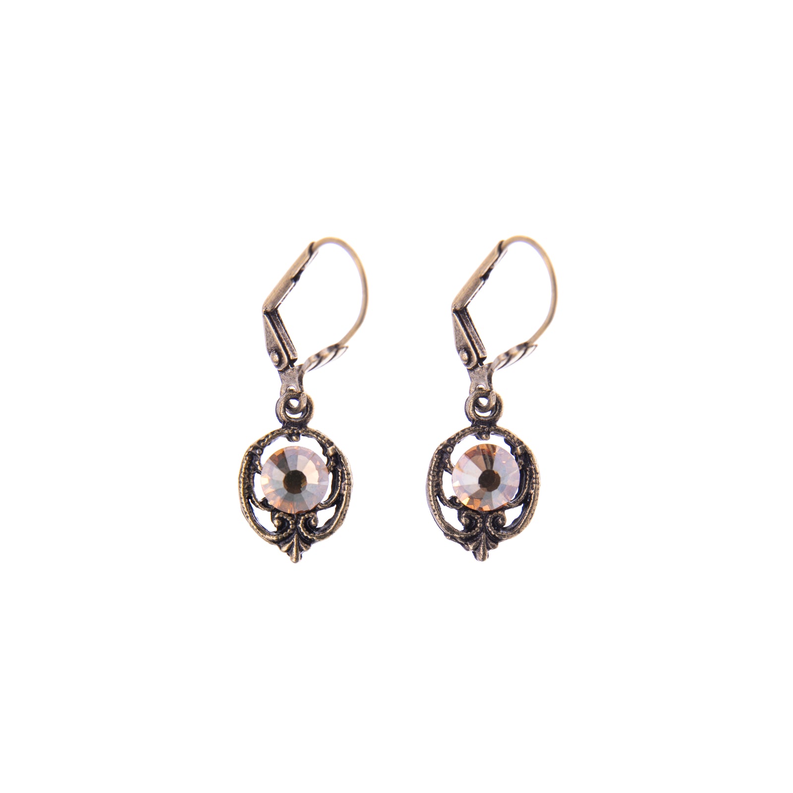 Designed with a vintage flair, these Golden Shadow Crystal earrings shimmer with golden glam. These dainty dangle earrings with their scroll detail and golden crystals are perfectly fit for daily wear. Materials: Antiqued Brass, Surgical steel posts Dimensions: Approx. 1 1/4″ L x 7/16″ W Lead and Nickel-free