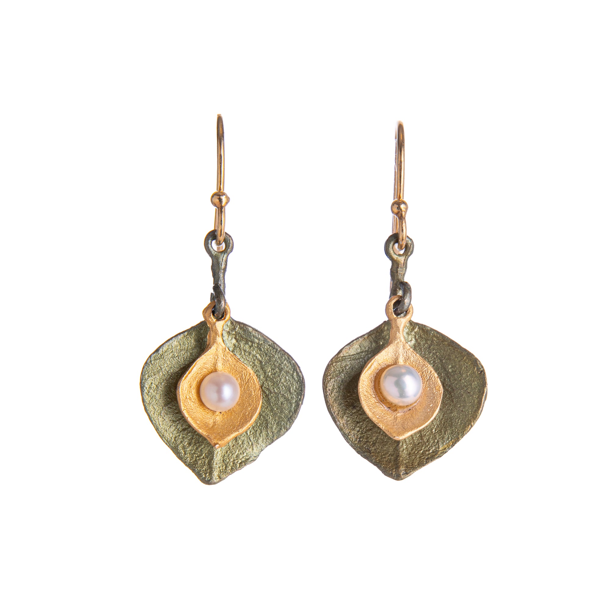 These beautifully delicate eucalyptus leaf earrings are cast in bronze with a subtle green patina and a 24kt gold plating, accented with white freshwater pearls. The wires are 24kt gold plated 925 Sterling silver. Size 0.85" L x 0.56" W Bronze with 24kt gold plating. Freshwater pearl accents. Gold plated ear wires.