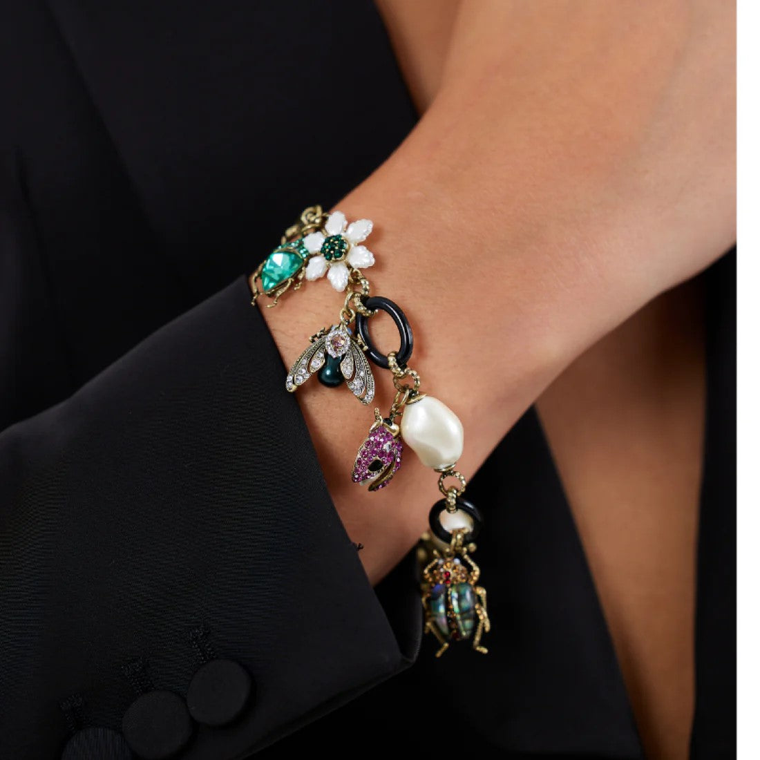 Celebrate your love of bugs with this bug charm bracelet. With its various charms, including a mother of pearl flower, bugs, and black oval rings, this bracelet will add whimsy to your jewelry collection. Dimensions: Chain Extender - Approx. 2", Chain Length - Approx. 7" Material: Gold-Plated Brass, Enamel, Acrylic
