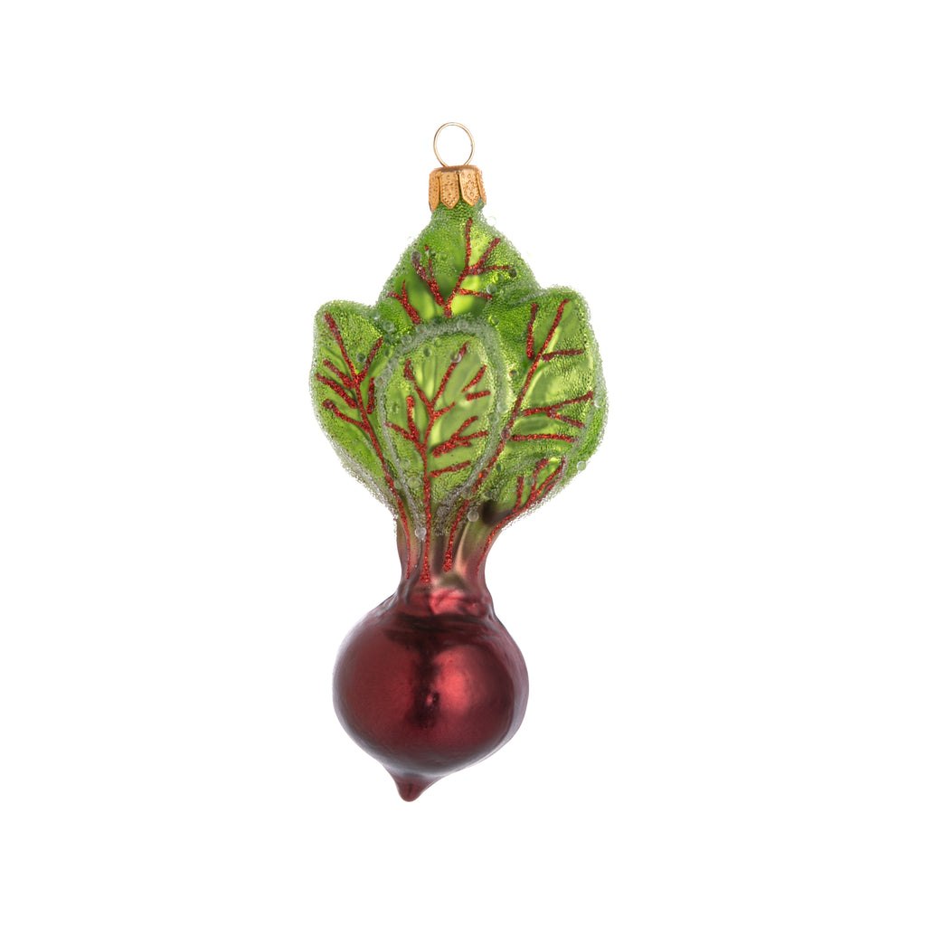 The earthiness of a red beet, in enchanted ornament form! Hand painted and coated in frosting, this Enchanted Red Beet ornament looks like it came fresh out of the ground and placed right onto your holiday decor. Hand painted glass ornament Dimensions: 5" x 2.25"