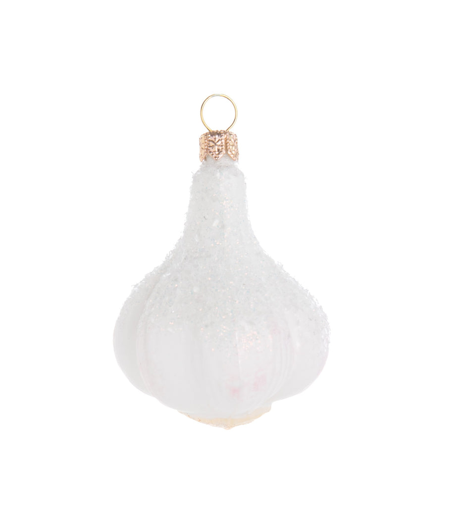 The humble garlic bulb gets a glittering makeover in this enchanting ornament. This carefully crafted glass ornament is generously sprinkled with iridescent glitter and is sure to add a wonderfully whimsical touch to your holiday decor. *May also keep vampires at bay. Hand crafted glass ornament. Dimensions: 3" x 2".
