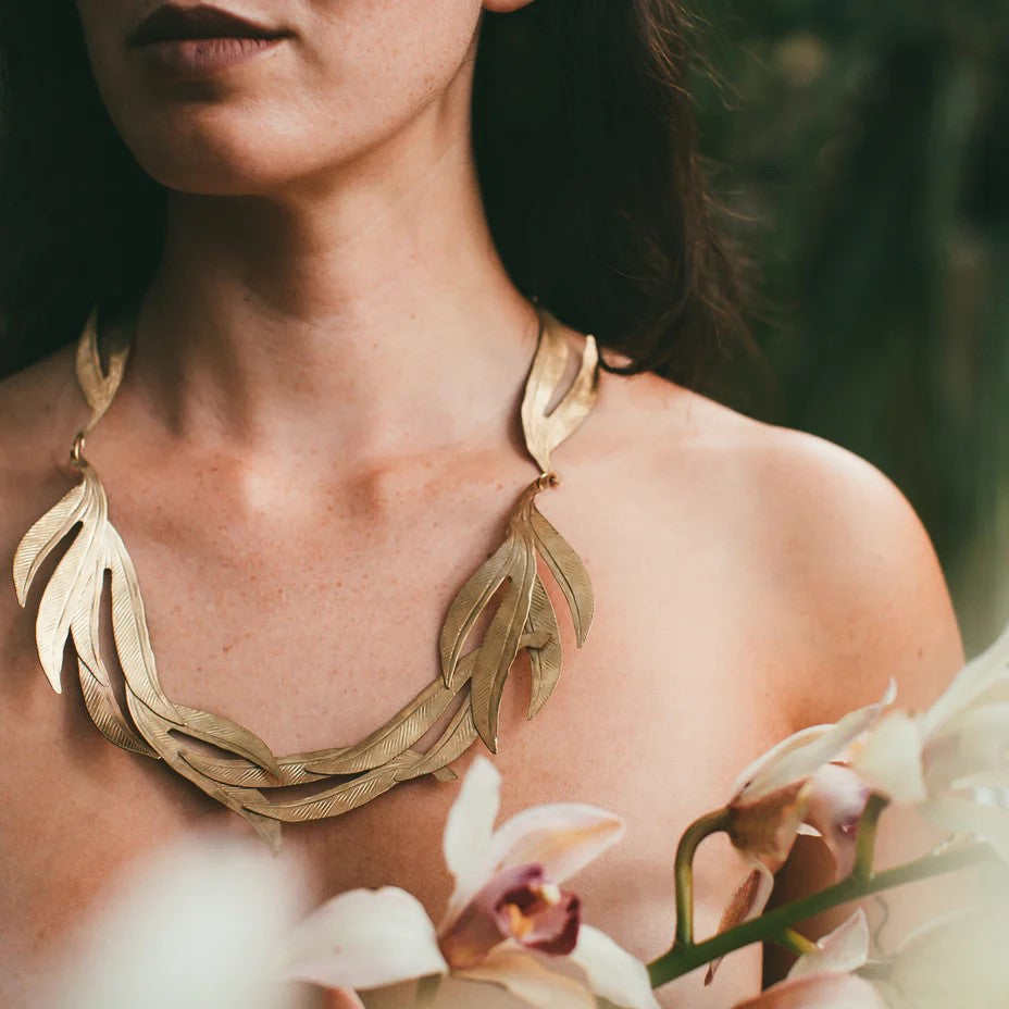 Look and feel like a goddess in this Maharani necklace that will instantly add a gold statement to any outfit. This necklace is adorned with leaf-like pieces evoking nature. Delicate detail shines in light but very durable hand-hammered brass. Material: Hand-hammered brass  Dimensions: 18" long Nickel and lead-free