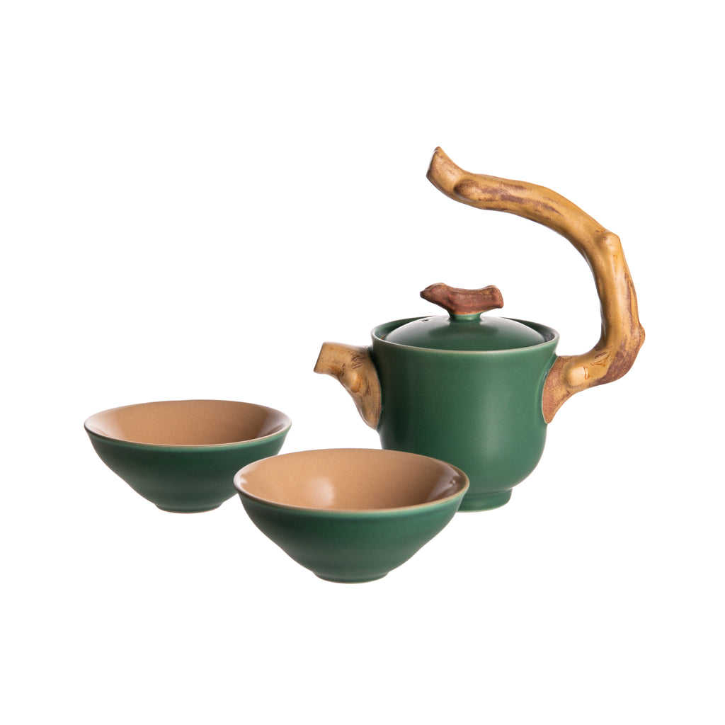 Add some whimsy to your teatime with this delightful tea set. Made from durable ceramic with a deep green glaze, the teapot features a handle, spout, and lid handle in the shape of tree branches. The two matching cups are handleless and perfect for sipping your favorite tea. Pot size: 3.25" x 6.5" Cups 3.25" x 1.25". 