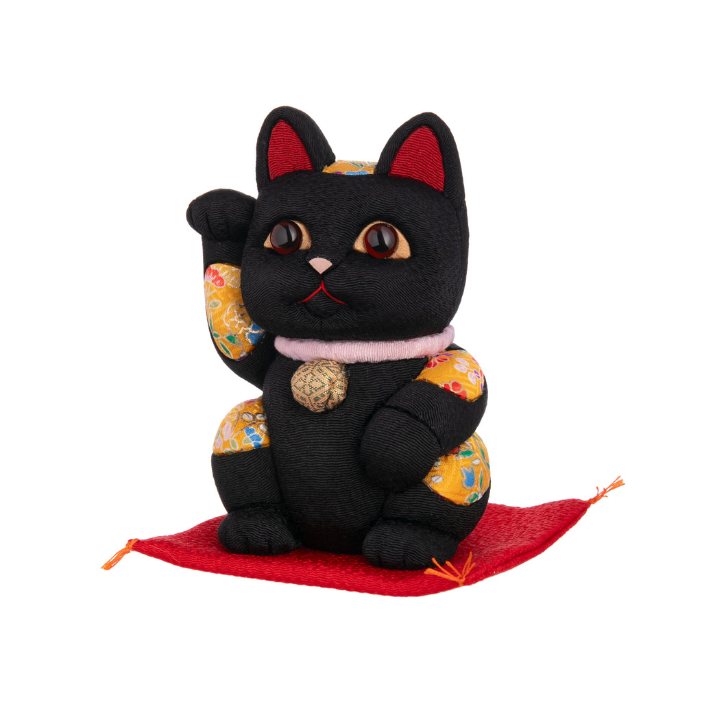 This Lucky Cat is sure to be a lucky addition to your home or even a great gift to send good fortune to friends or family.  With glowing brown eyes, red ears, a pink collar, and gold detail, this Lucky Cat wants to make sure your wishes come true!  Dimensions: approx. 5"x 3"x 3" Materials: crepe silk, polyurethane