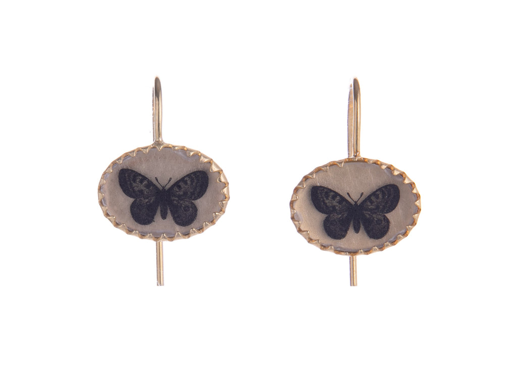 These delicate earrings have a vintage feel and feature hand drawn, Victorian inspired entomology style butterfly artwork set in a scalloped gold vermeil frame. Each pair is individually crafted by hand. Materials: Gold vermeil, resin Handmade with hand-drawn artwork Hook fastening Dimensions: 0.75" x 0.5"