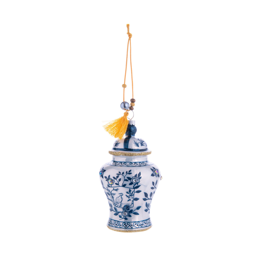 With its intricate blue and white patterns, this Ginger Jar glass ornament is charming and inspired by vintage chinoiserie jars. Decorated with gold glitter and rhinestones, this ginger jar will elevate your home and holiday decor. Comes with ribbon for hanging. Dimensions: Approx. 4.5" H x 2.5" W Glass ornament