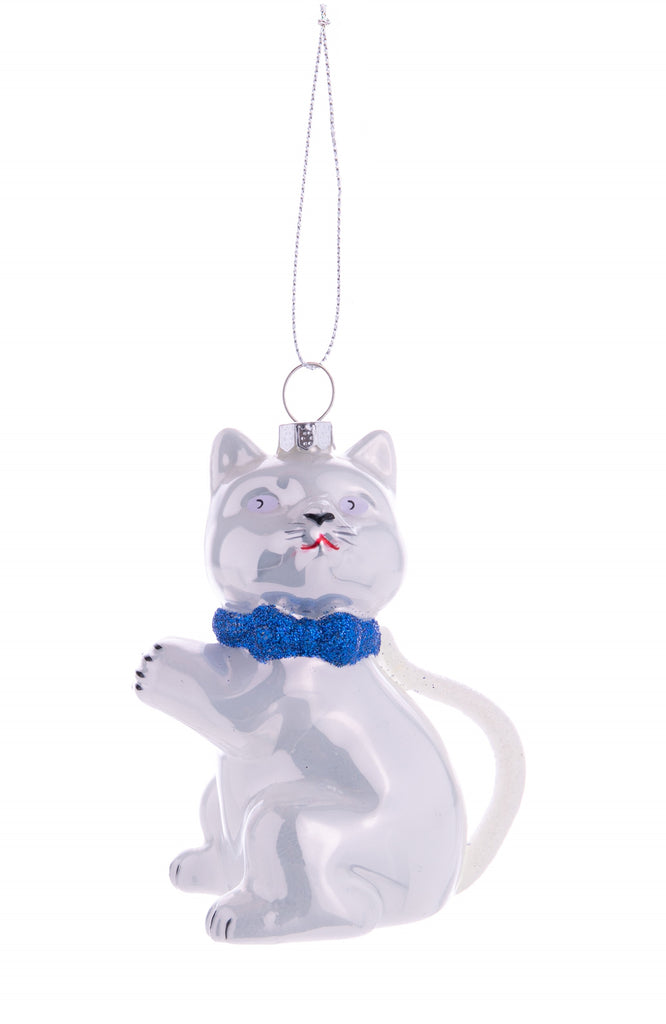 This Lucky Cat glass ornament is sure to be your new good luck charm.  Detailed with blue and white glitter on its tail and cute bowtie, this cat is an adorable ornament for hanging in the home as an addition to holiday decor or just to bring you some extra luck. Dimensions: 3.5" x 2.5" Glass ornament