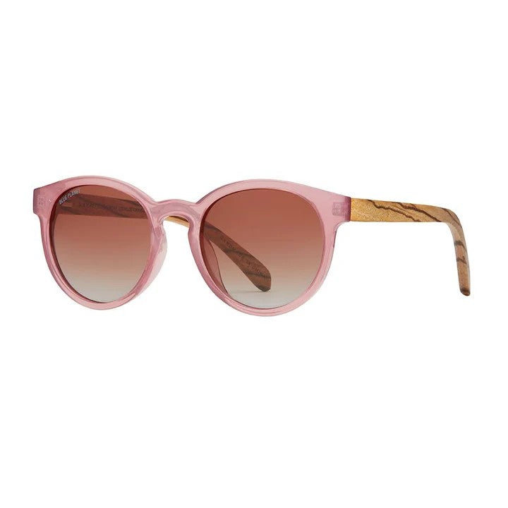 These rounded sunglasses in rose with zebra wood detail go with any outfit. Hand polished ultra-lightweight eco-friendly frames reuses 60-75% recycled & reprocessed content. Dimensions: Lens Width - Approx. 2", Bridge Width - Approx. 0.7", Temple Length - Approx. 5.6" 100% UVA/UVB Protection Premium Polarized Lenses