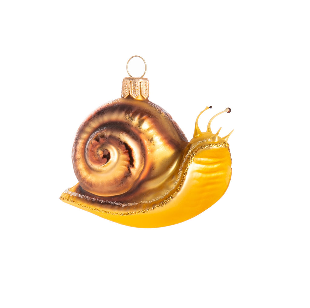 Take in the slow-paced life with this gorgeous glass snail ornament. Comes in both gold and green, as well as glitter and frosted detail to add a little magic to these slow-moving bugs. Glass ornament Dimensions: approx. 2" x 3" x 1.5"