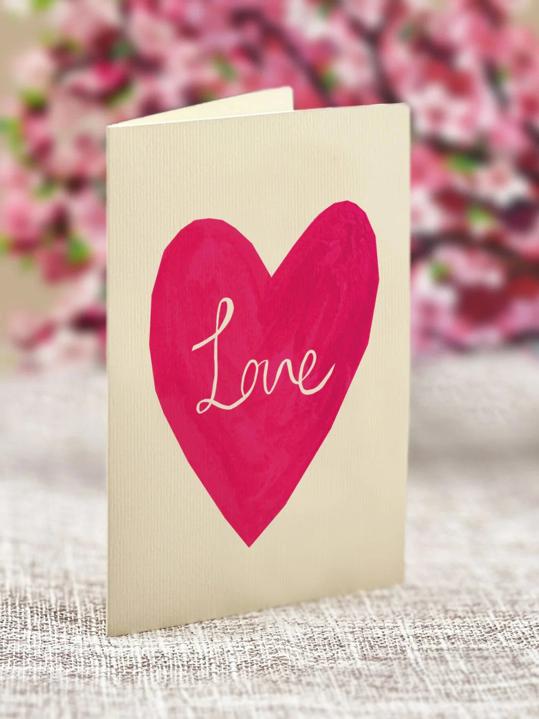 This sweet mini pop-up heart features soft pink sakura petals that can be sent as a gift so you can share the love. This charming foldable paper display will remain in bloom all year round. Measures approximately 6” high by 5" across 100% Recyclable Paper Comes with a blank 2.5" x 3.5" notecard and mailing envelope