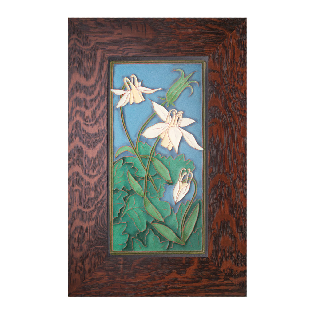 Expertly handcrafted in an artisan workshop in Portland, Maine. This ceramic tile features a relief of a Columbine flower against an early evening sky. The tile is surrounded by a 2.5" quarter sawn oak frame. Each tile carries the artist's stamp and has a brass picture hook at the back. Size including frame: 17" x 11" 