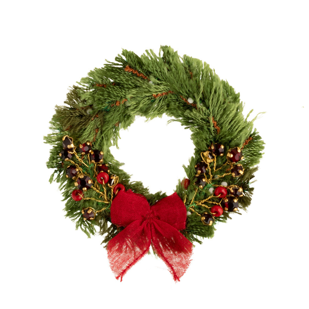 Christmas wreath brooch with a red bow on a white background