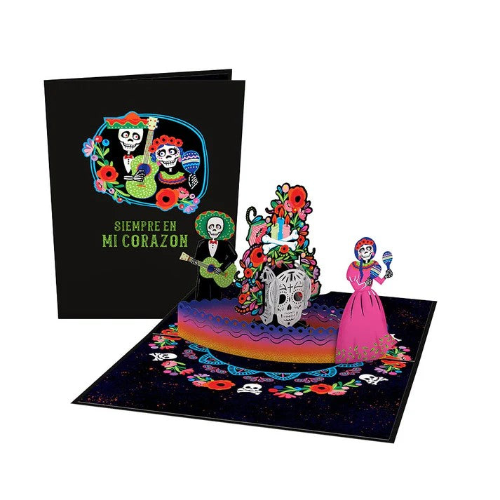 Dia de Muertos is celebrated from October 31st through November 2nd. Honor and pay tribute to loved ones and ancestors with this vibrant 3D pop-up notecard. With calaveras and altar offerings, this card is perfect for sending along a note to celebrate loved ones. Includes blank envelope and notecard Dimensions: 5" x 7"