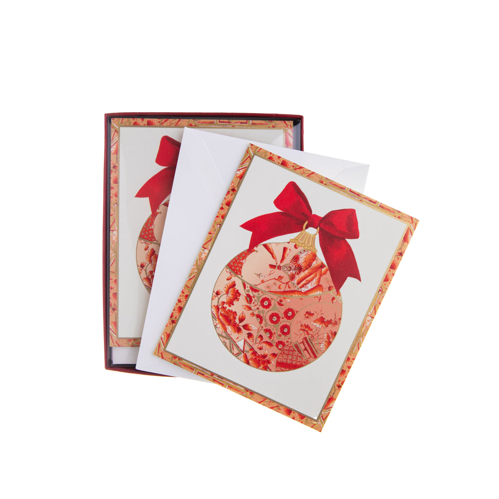 Gilded and gold, these boxed holiday notecards feature round ornaments with a red bow to send greetings, salutations, and holiday wishes. The box has 15 cards and 15 envelopes. Inside the card is the message "Greetings of the Season" to send your loved ones your best. Dimensions: 3.75" x 4.75" 