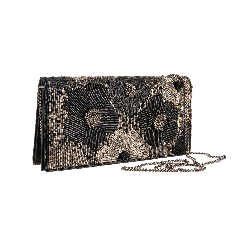 With black and silver beads, this flower clutch is perfect for a night on the town. The interior has credit card slots, an ID slot, and an inside zippered compartment. The clutch can also convert to a crossbody as it comes with a chain. Dimensions: 8.5" L x 2" W x 4.5" H Material: Cotton Dupion Fabric, Beads, Iron