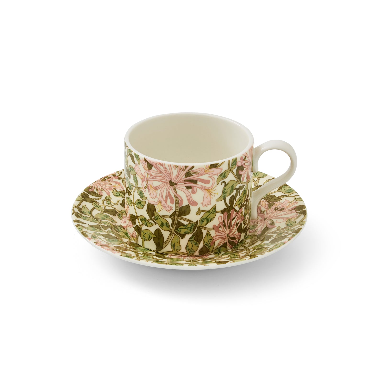 A white porcelain teacup and saucer with a green and pink floral pattern based on the William Morris Honeysuckle design.