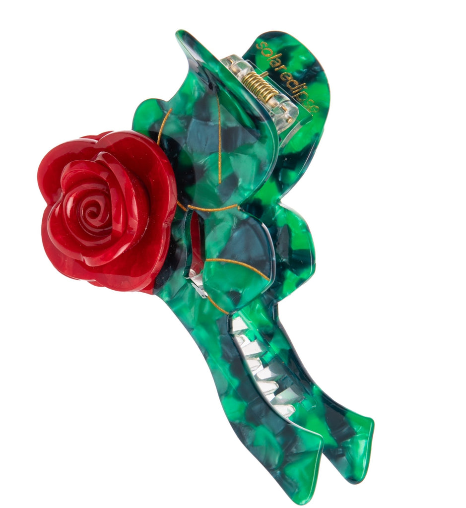 Add a rosy flourish with this hand-finished origami rose stem claw hair clip. It is double sided and has hand-painted accents. Made from premium materials including a biodegradable wood pulp acetate, making these clips kind to the environment! 100% plastic-free and recyclable packaging Dimensions: Approx. 4" x 2.5" 