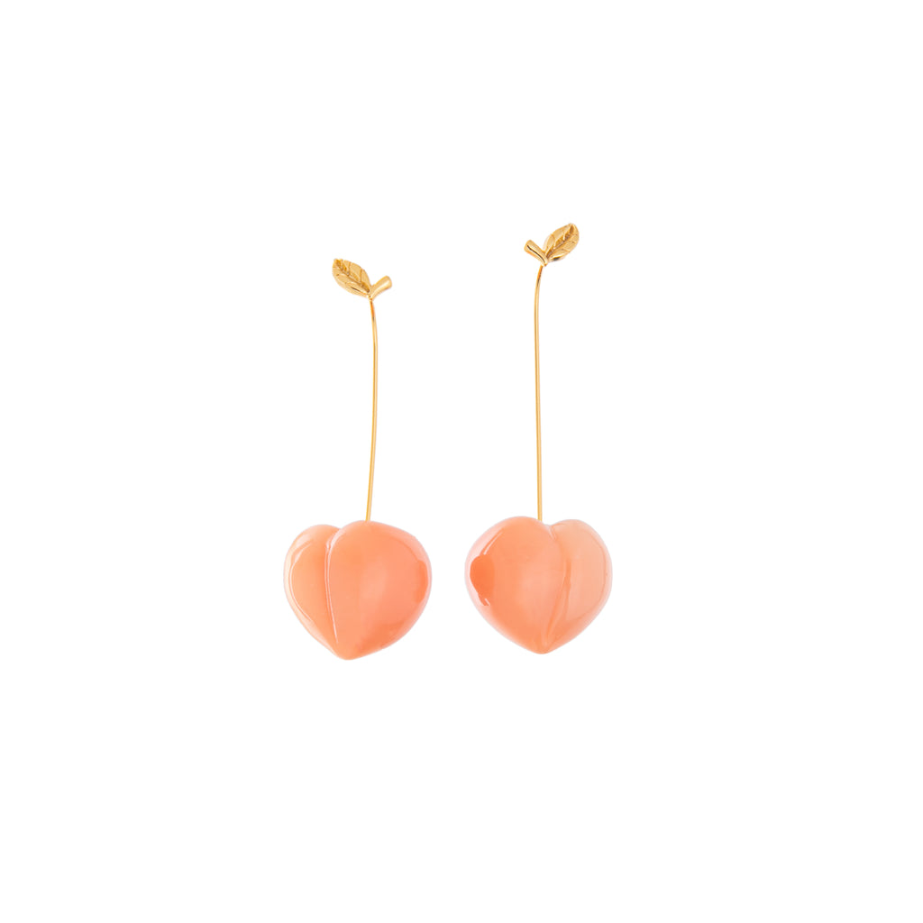 Hanging from golden leaf studs, these cute resin peaches dangle from your ears with the utmost charm. Perfect for a picnic, or a sweet evening out, these are great for adding some eclectic appeal to any outfit. Material: Brass, Resin Dimensions: Approx. 2" Length, 0.8" Width Wire drop closure Lead and Nickel-free