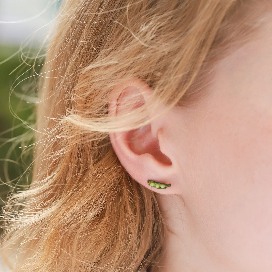These pea pod post earrings are the subtlest hint of green, while showing off your love of this legume. With a stud post backing and their smaller size, these are perfect for daily wear. Materials: Brass, Acrylic, Enamel Dimensions: Approx. 0.4" Length, 0.1" Width Stud post backing Lead and Nickel-free