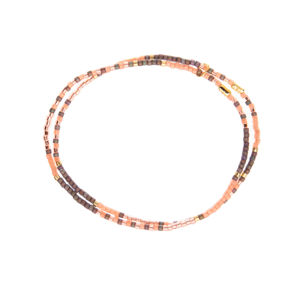 This double-strand bracelet with Miyuki Japanese glass beads encapsulates a subtle rose gold sparkle. The bracelet features shimmering rose, taupe, and rose gold beads. On a stretchy band with a connecting loop, this will look great layered or on its own. Dimensions: Approx. 2" diameter Stretchy double-strand bracelet