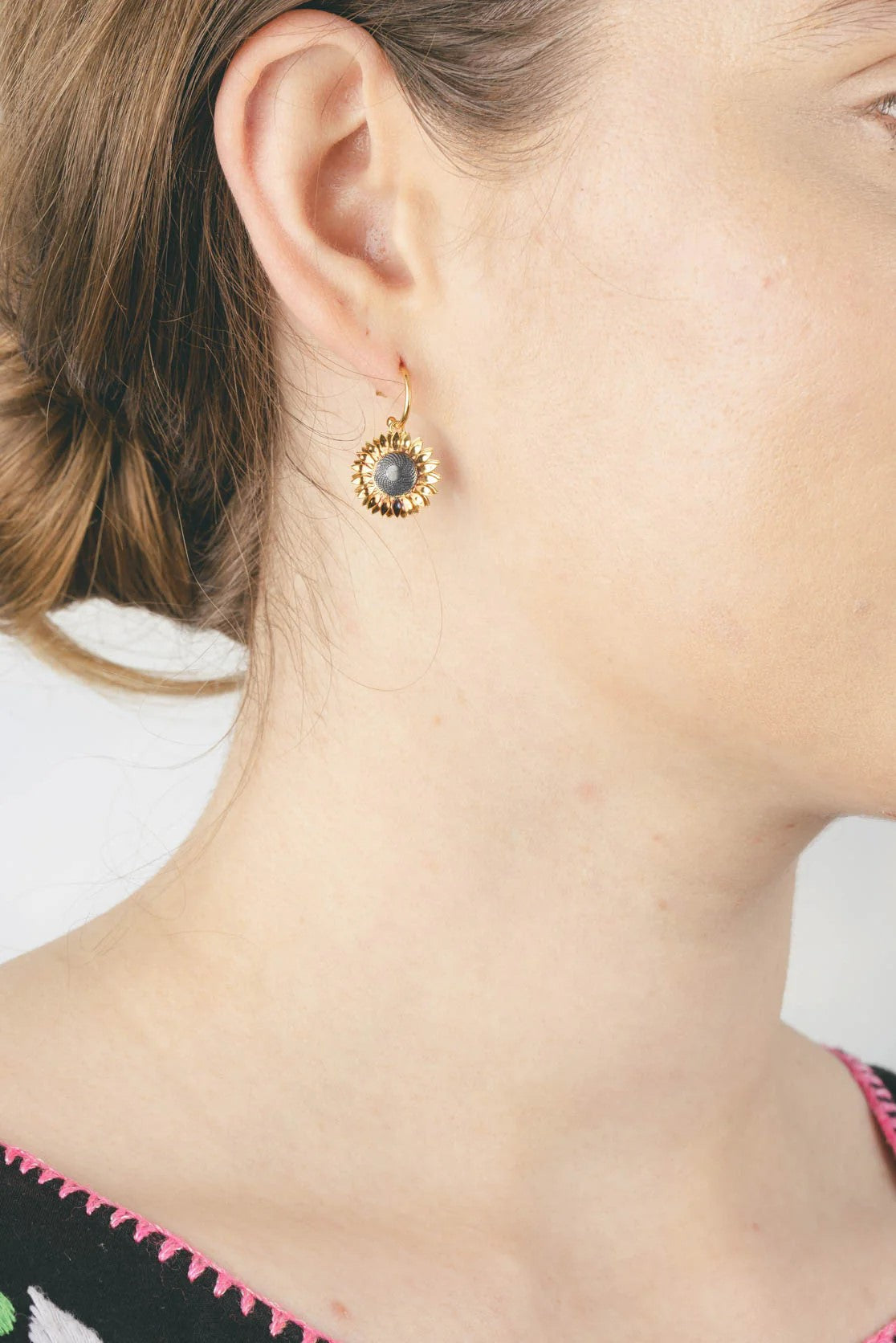 Spread joy with these sunflower hoop earrings. With gold detail for the petals, the center of the earring is oxidized silver to make the yellow stand out. 