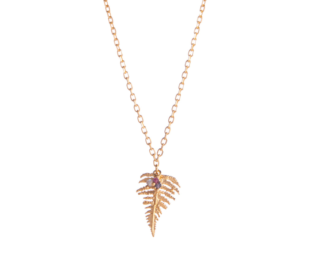 This gold fern pendant necklace is subtle enough for daily wear, and features a mix of delicate garnet, iolite, and labradorite beads hooked to the fern leaf. 