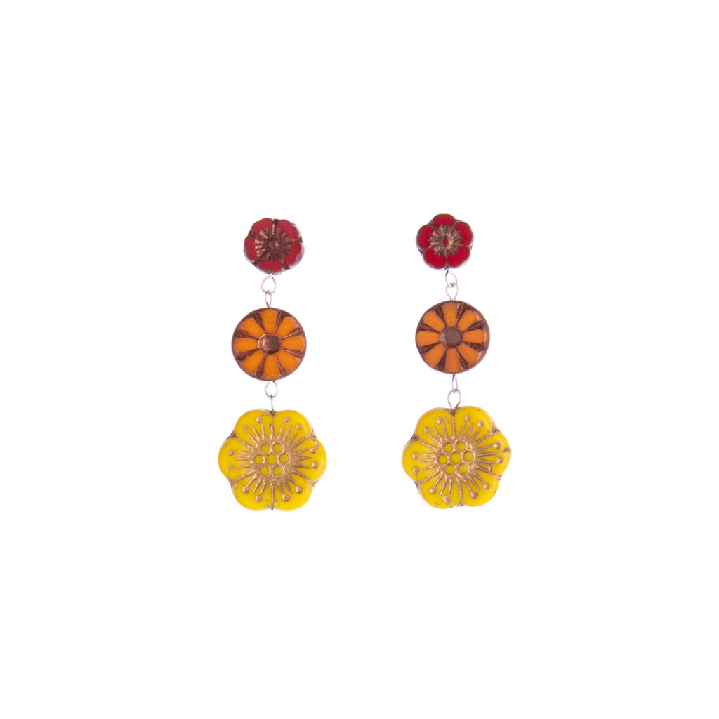 Celebrate the beauty of the botanical. Featuring glass flower beads in red, orange, and yellow, these dangly earrings are sure to show off your love of all flowers. With their bright bold colors, they will help you make a stunning statement.  Handmade from glass Stud post earrings Dimensions: Approx. 1.6" Length