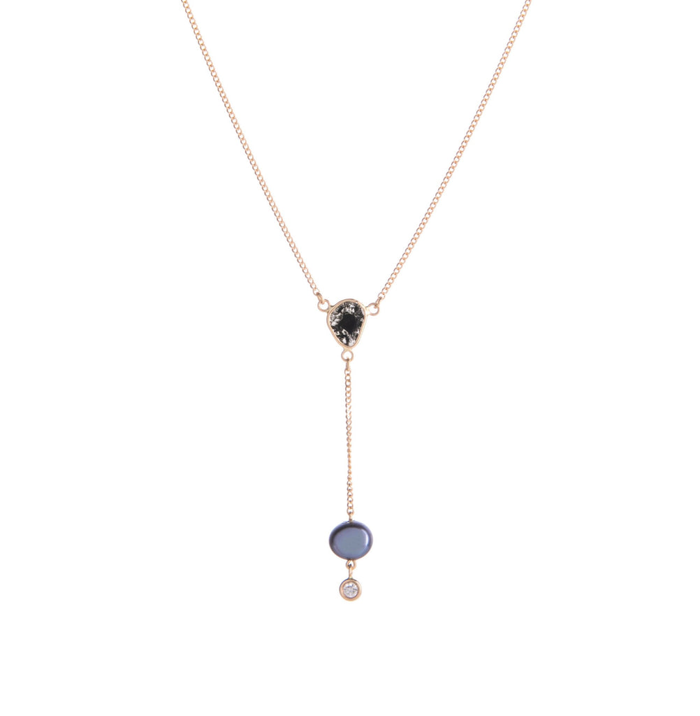 Subtlety meets glamour in this understated but very elegant lariat necklace. Featuring a freshwater peacock pearl at the bottom with a tiny white diamond, this lariat necklace also boasts a very unique black diamond slice situated just above. On a delicate 14k gold chain.