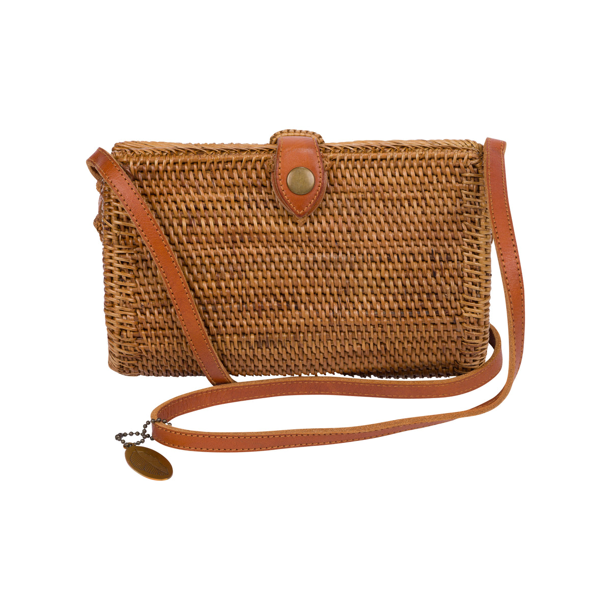 A woven straw crossbody bag with a tan leather strap and a brass snap button closure, shown against a plain white background.