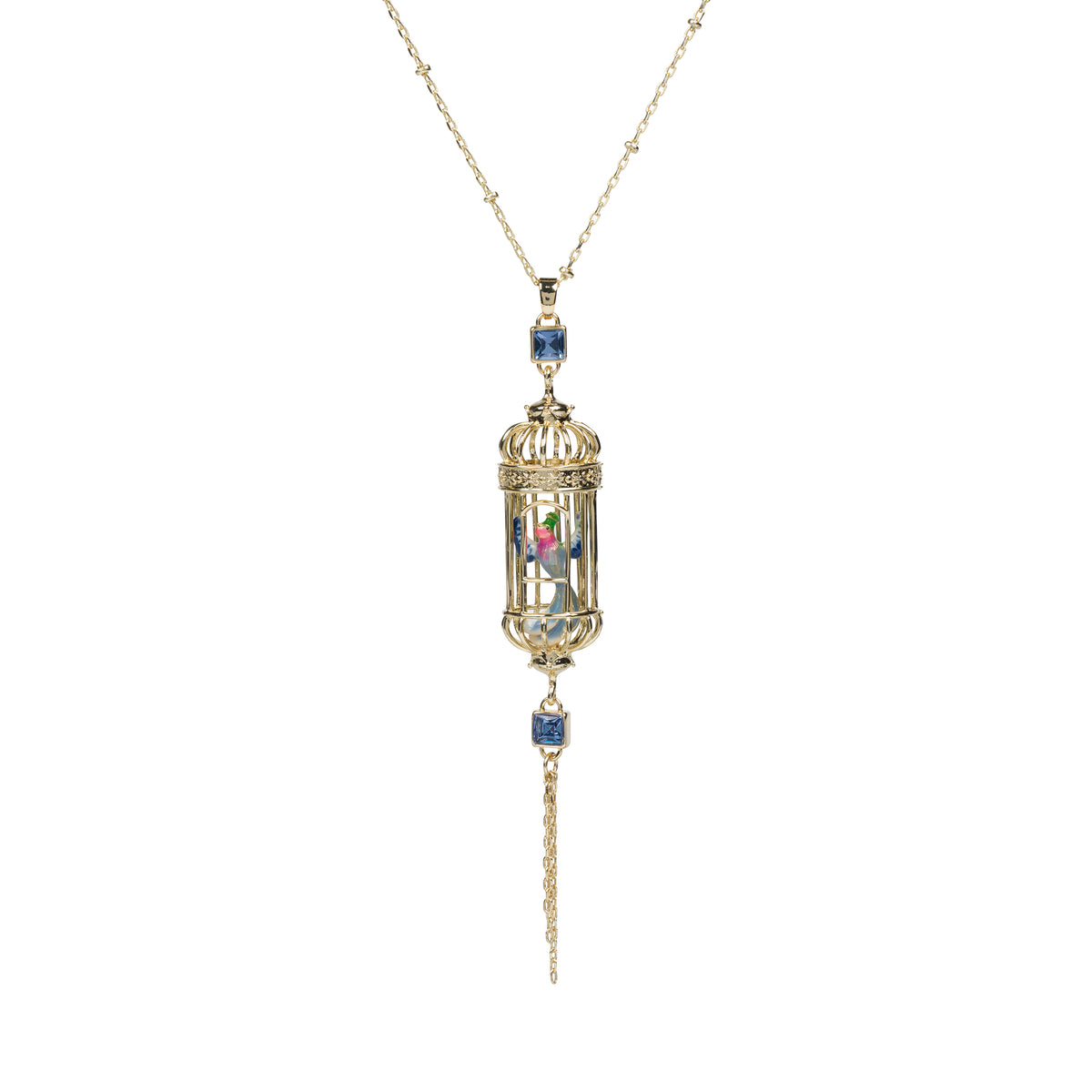 A gold pendant necklace featuring a miniature birdcage design with a colorful interior, accented by blue gemstones, shown against a plain white background.