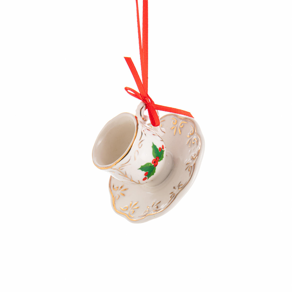 Decorative teacup and saucer ornament with holly design on a white background