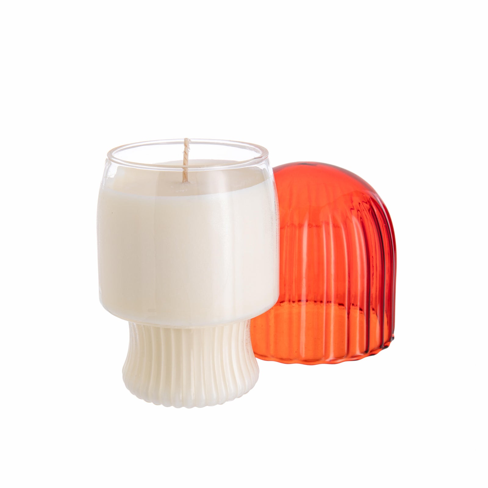 Red mushroom-shaped glass candle holder with scented candle inside, on a white background