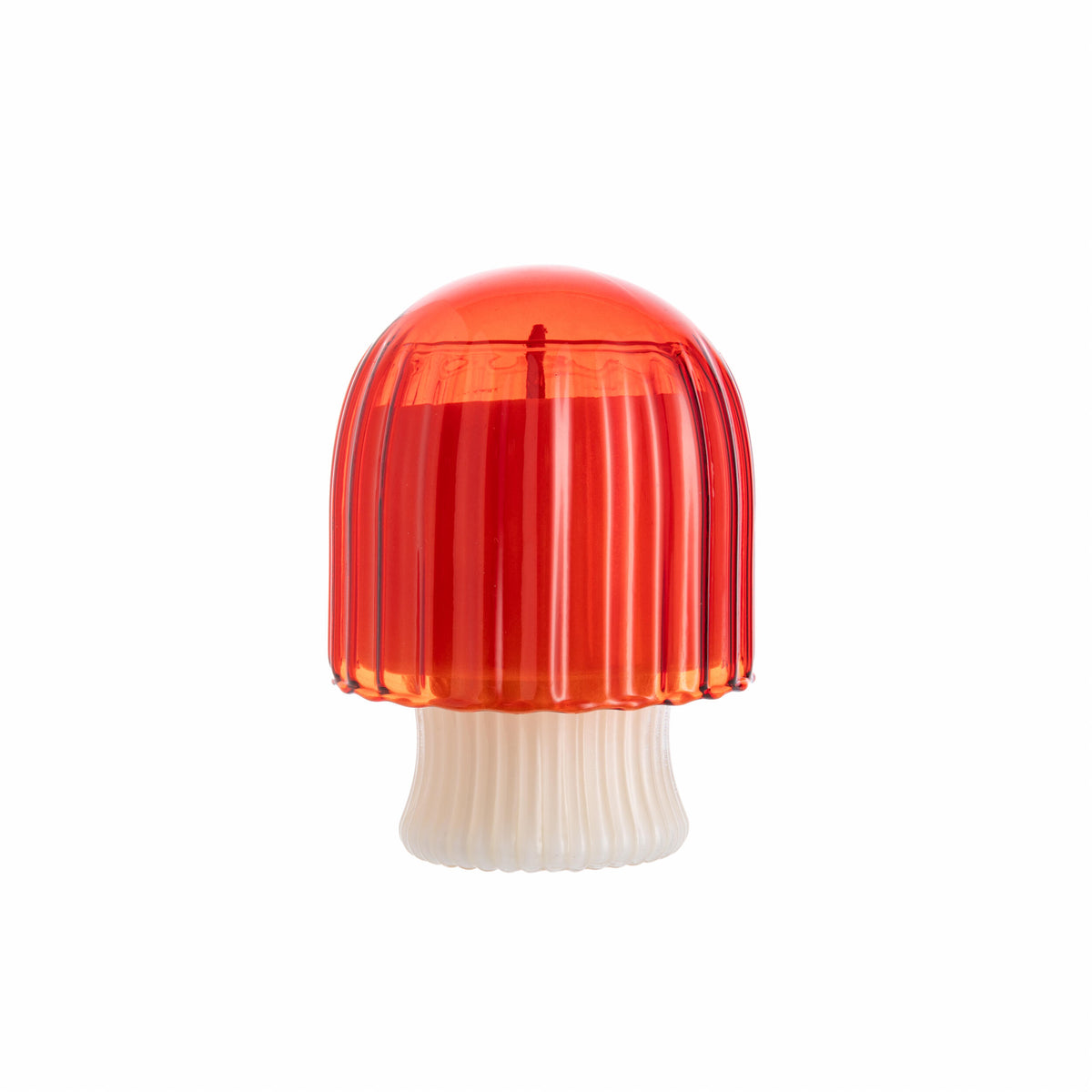 Red mushroom-shaped glass candle holder with scented candle inside, on a white background