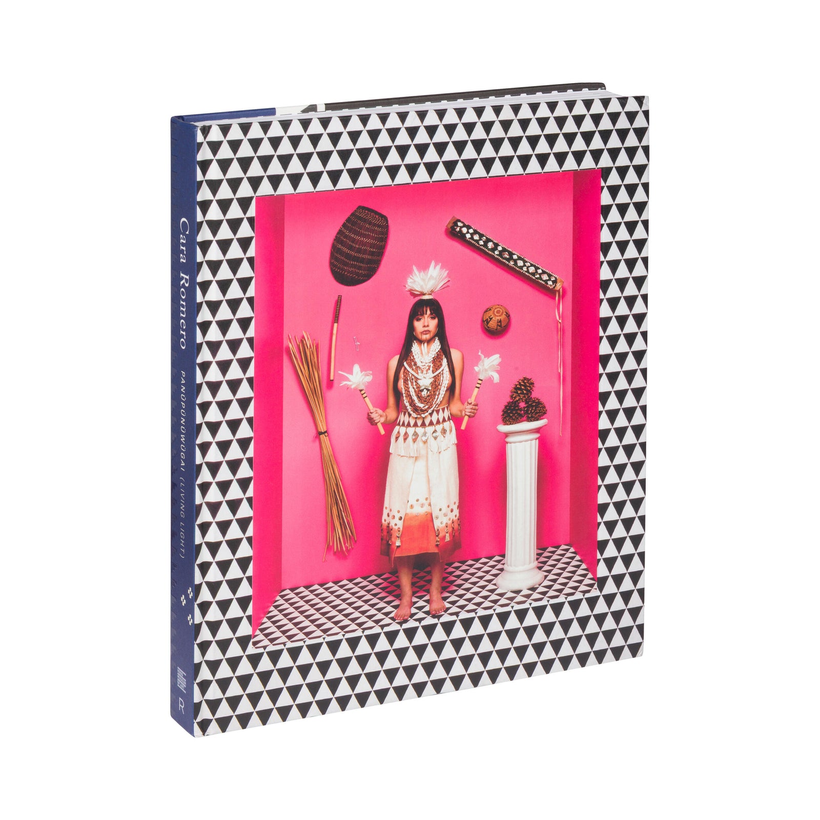 Book on the photography of Cara Romero with a geometric black and white pattern on the cover, featuring a pink interior with decorative items.