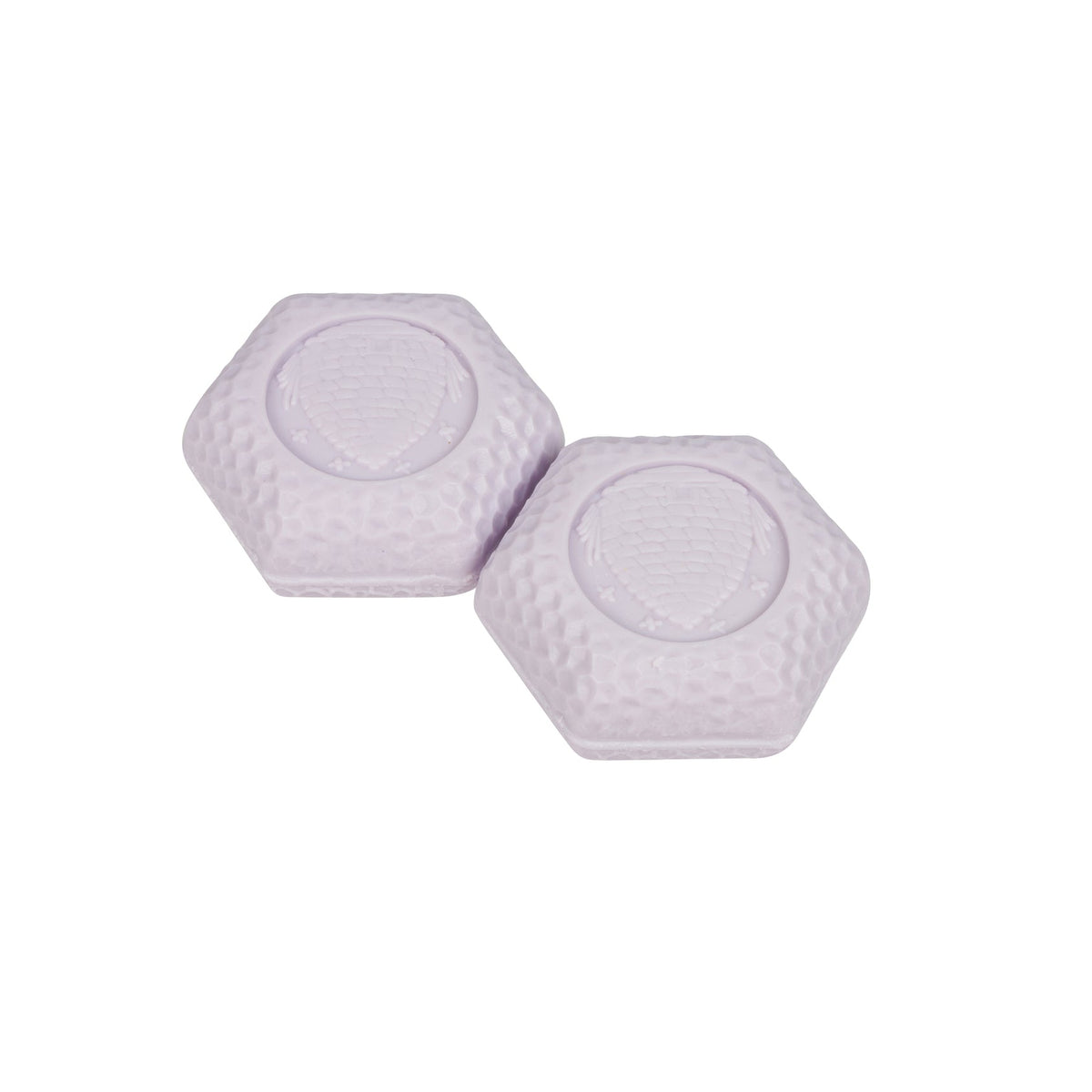 Two small hexagonal white textured bar soaps with circular raised centers, shown on a plain white background.