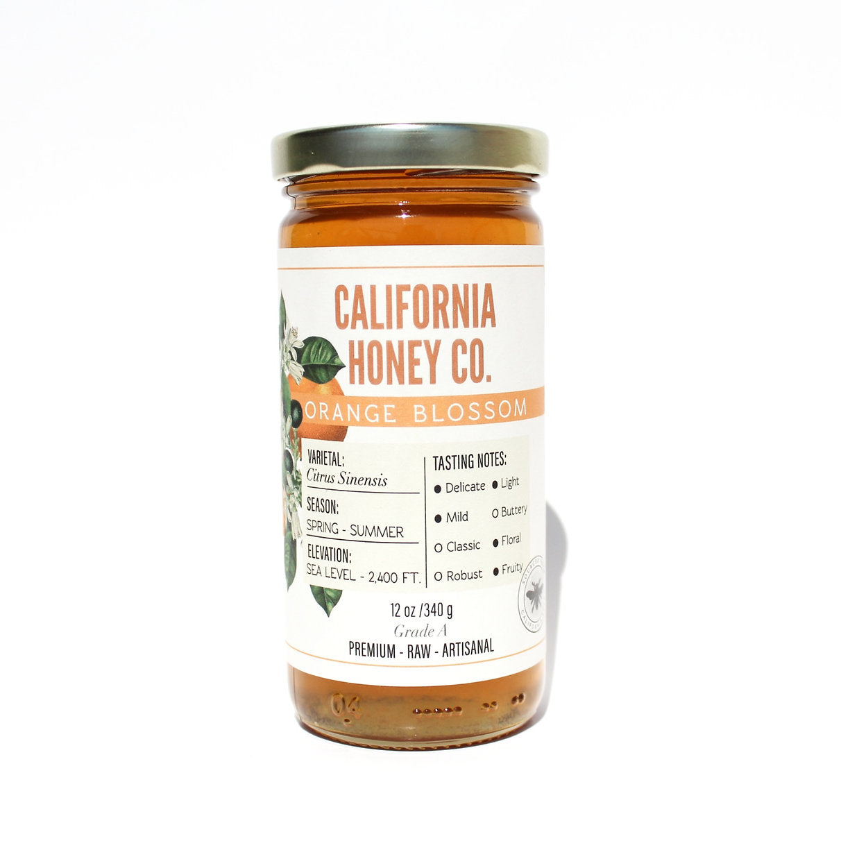 A glass jar of California Honey Co. Orange Blossom honey with a white label and silver lid, set against a plain white background.