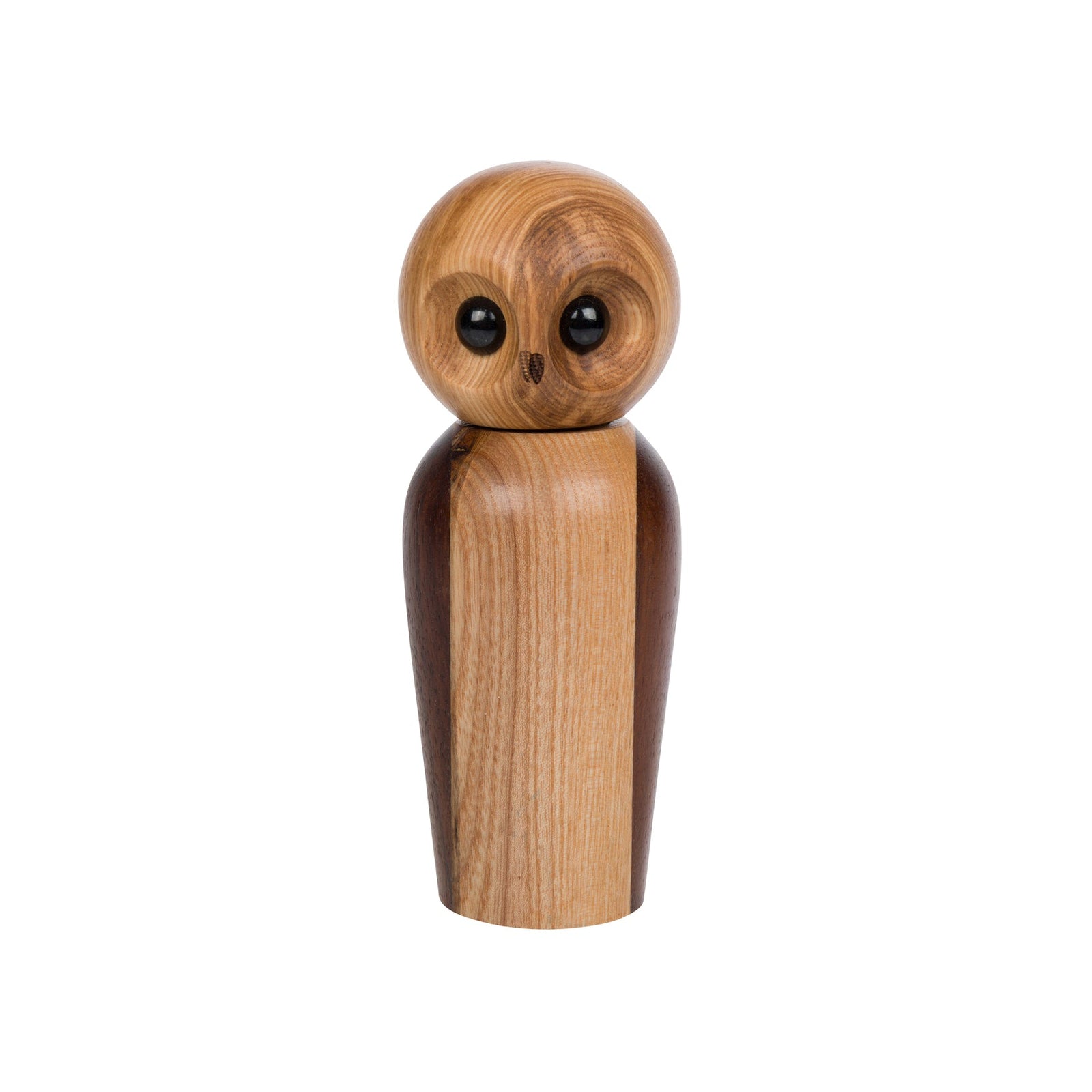 A minimalist wooden owl figurine pepper grinder with a round light brown head, dark brown eyes, and a tapered body made of alternating light and dark wood panels, set against a plain white background.