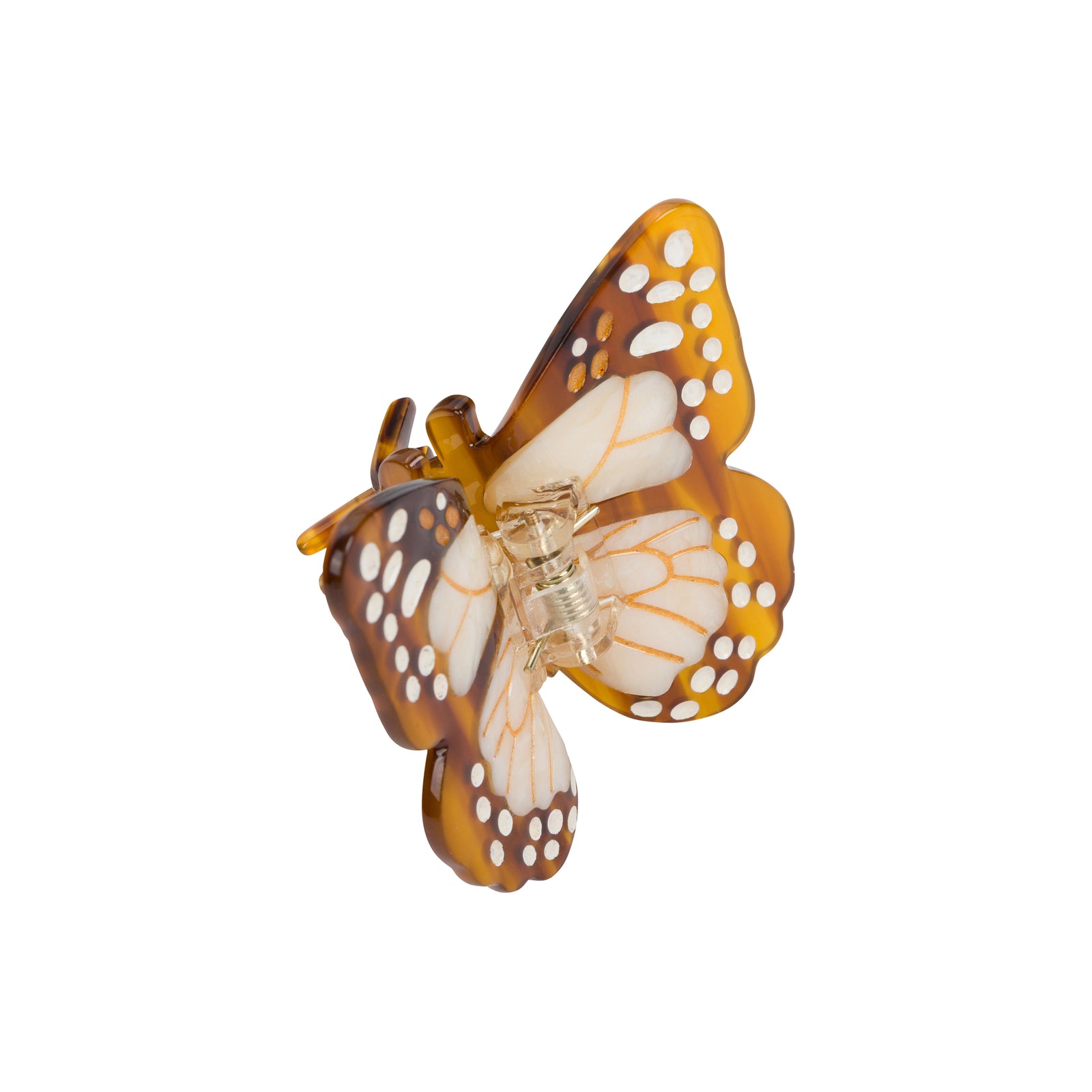 A butterfly-shaped hair claw clip made of translucent amber-brown and white resin with cutout details, shown on a plain white background.
