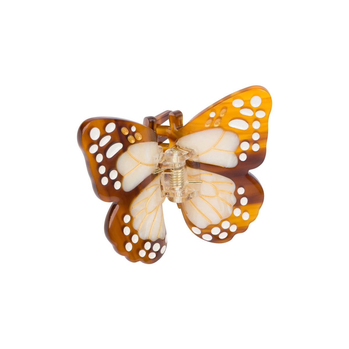 A butterfly-shaped hair claw clip made of translucent amber-brown and white resin with cutout details, shown on a plain white background.