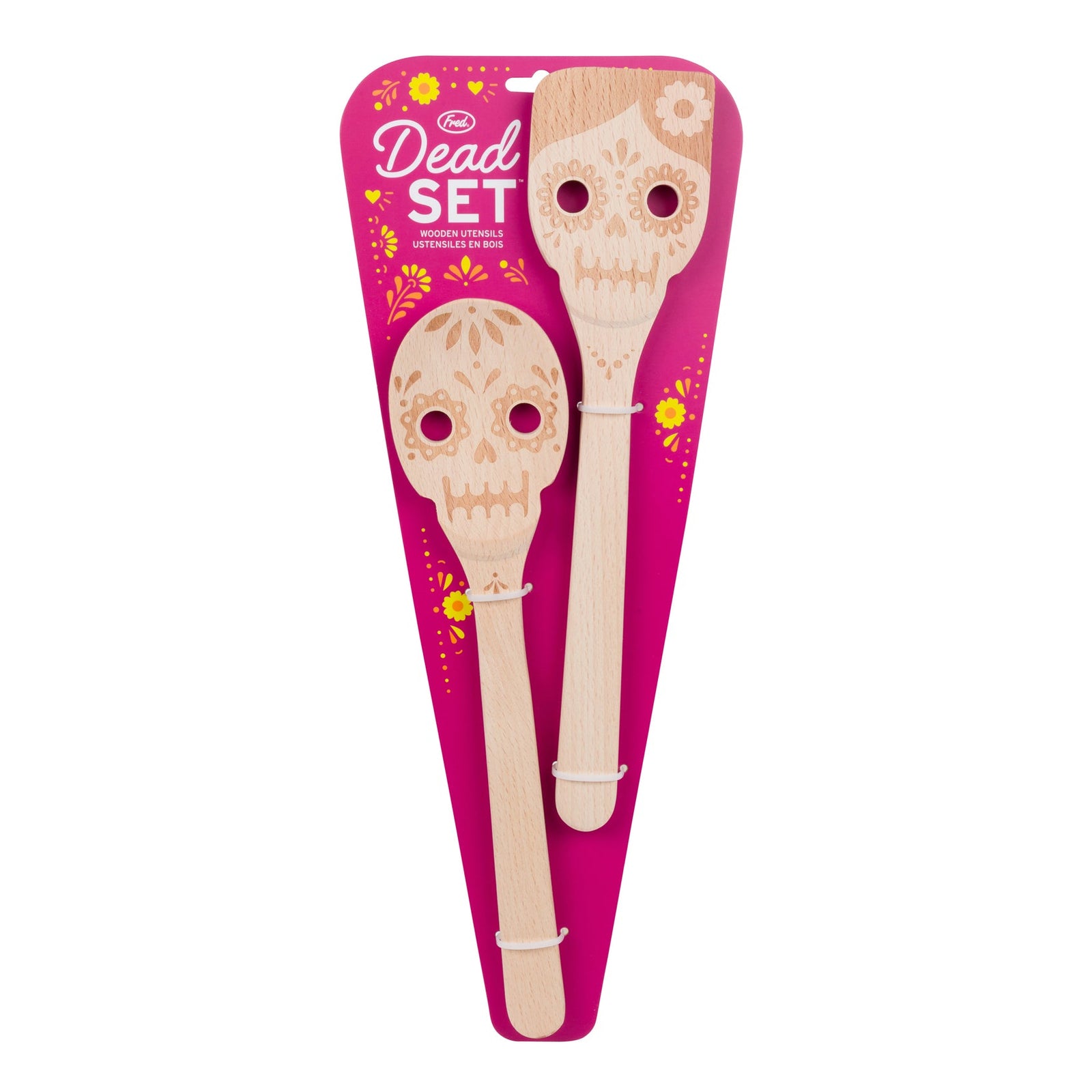 A wooden spoon and spatula set with sugar skull designs, packaged on a bright pink 'Dead Set' backing card against a white background.