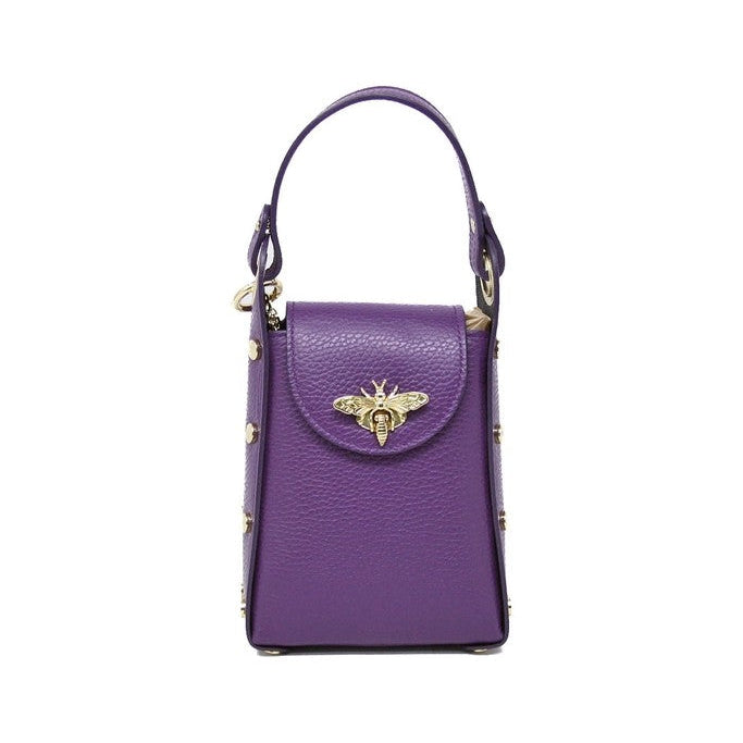 A purple pebbled leather handbag with a top handle, gold-tone studs, and a gold bee clasp on the front flap, shown against a plain white background.