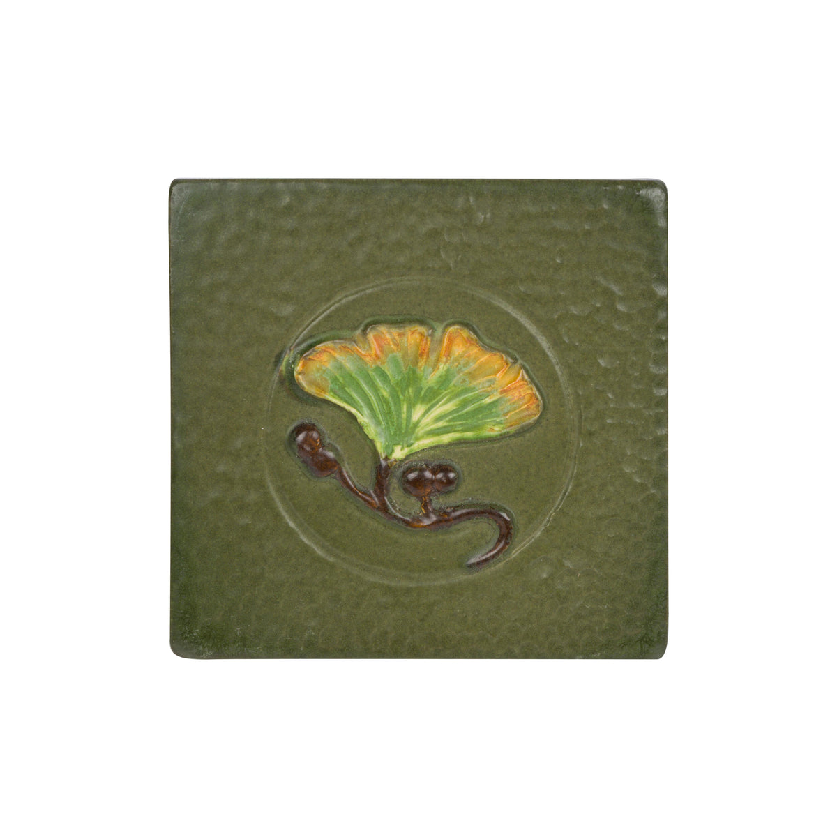 Green ceramic tile with a ginkgo leaf design on a white background