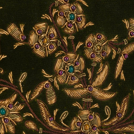 An olive green velvet clutch purse with intricate gold floral embroidery and small blue crystal accents, shown on a plain white background.